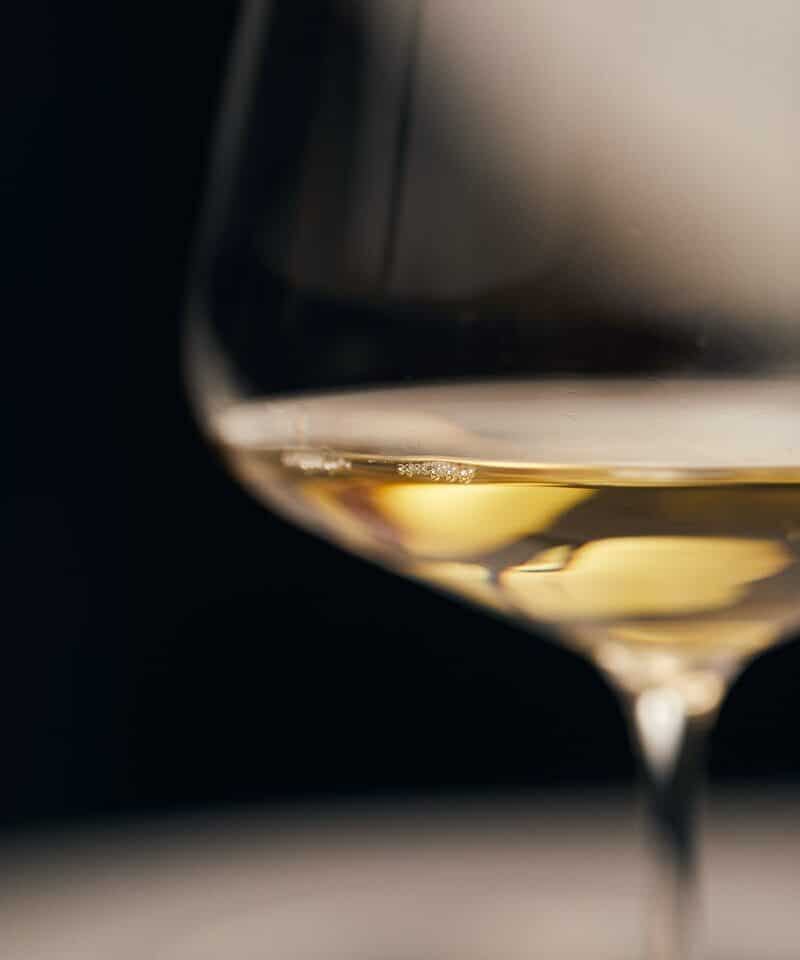 clear wine glass with yellow liquid